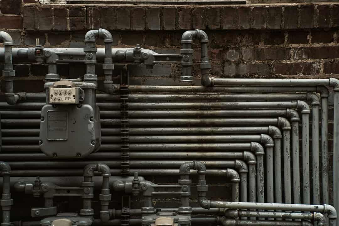Steel gas piping and a gas meter on a brick wall