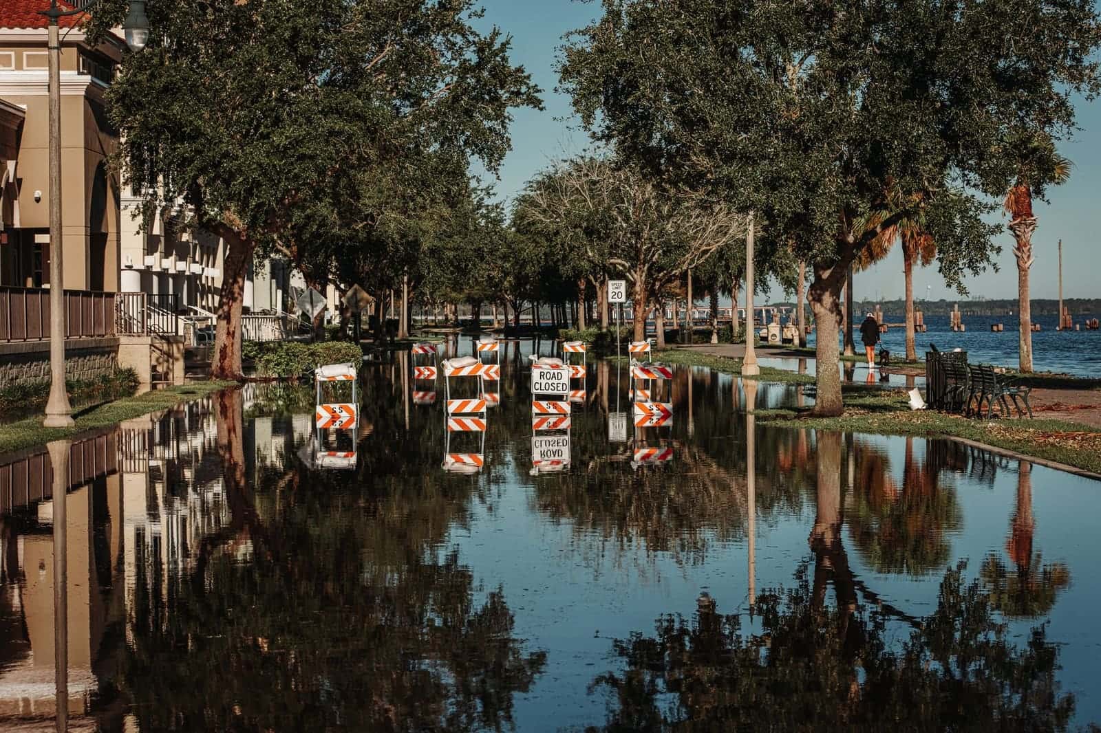Flooded residential street with road-closed barriers