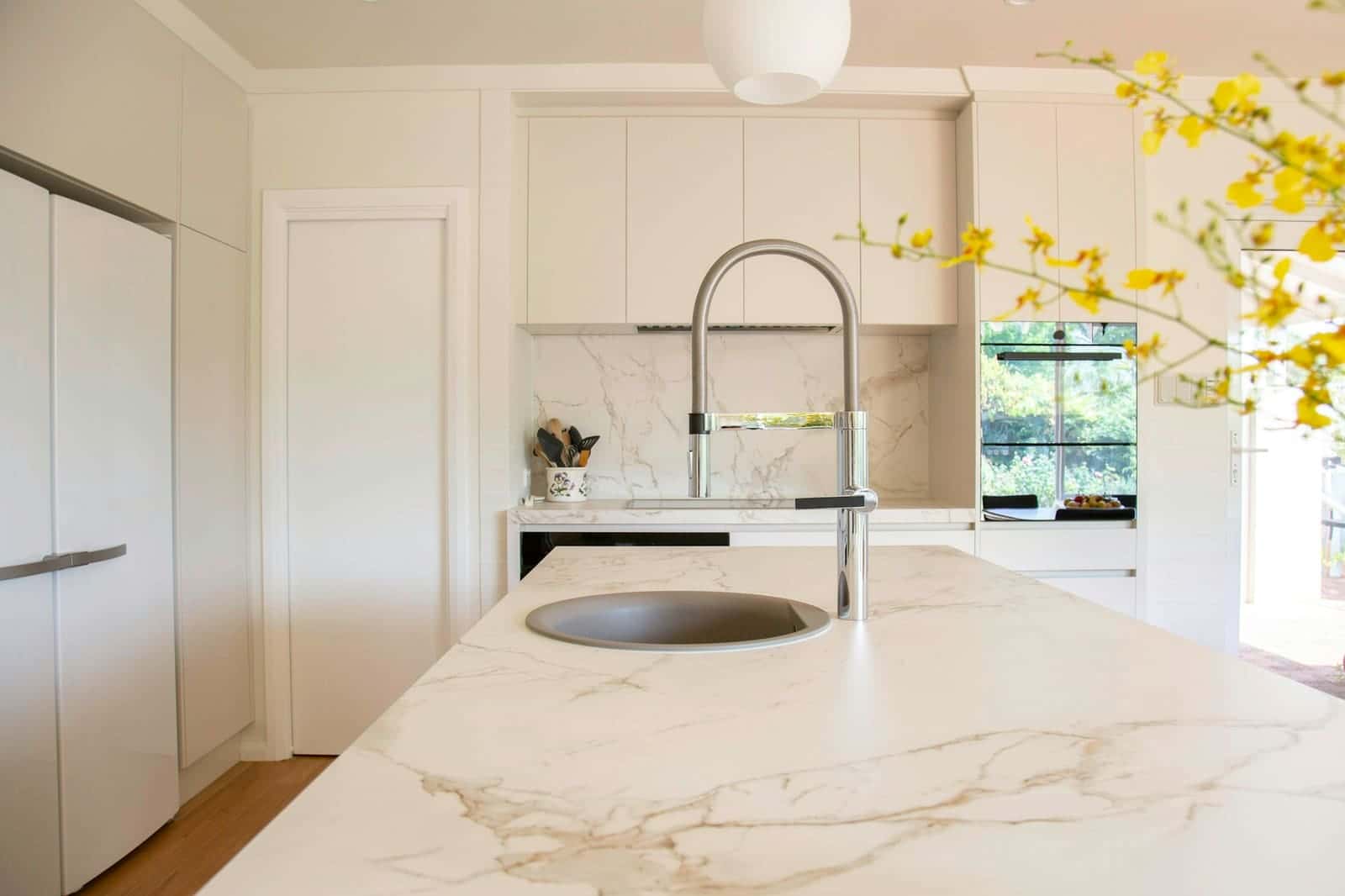Stainless kitchen faucet and sink in a bright kitchen
