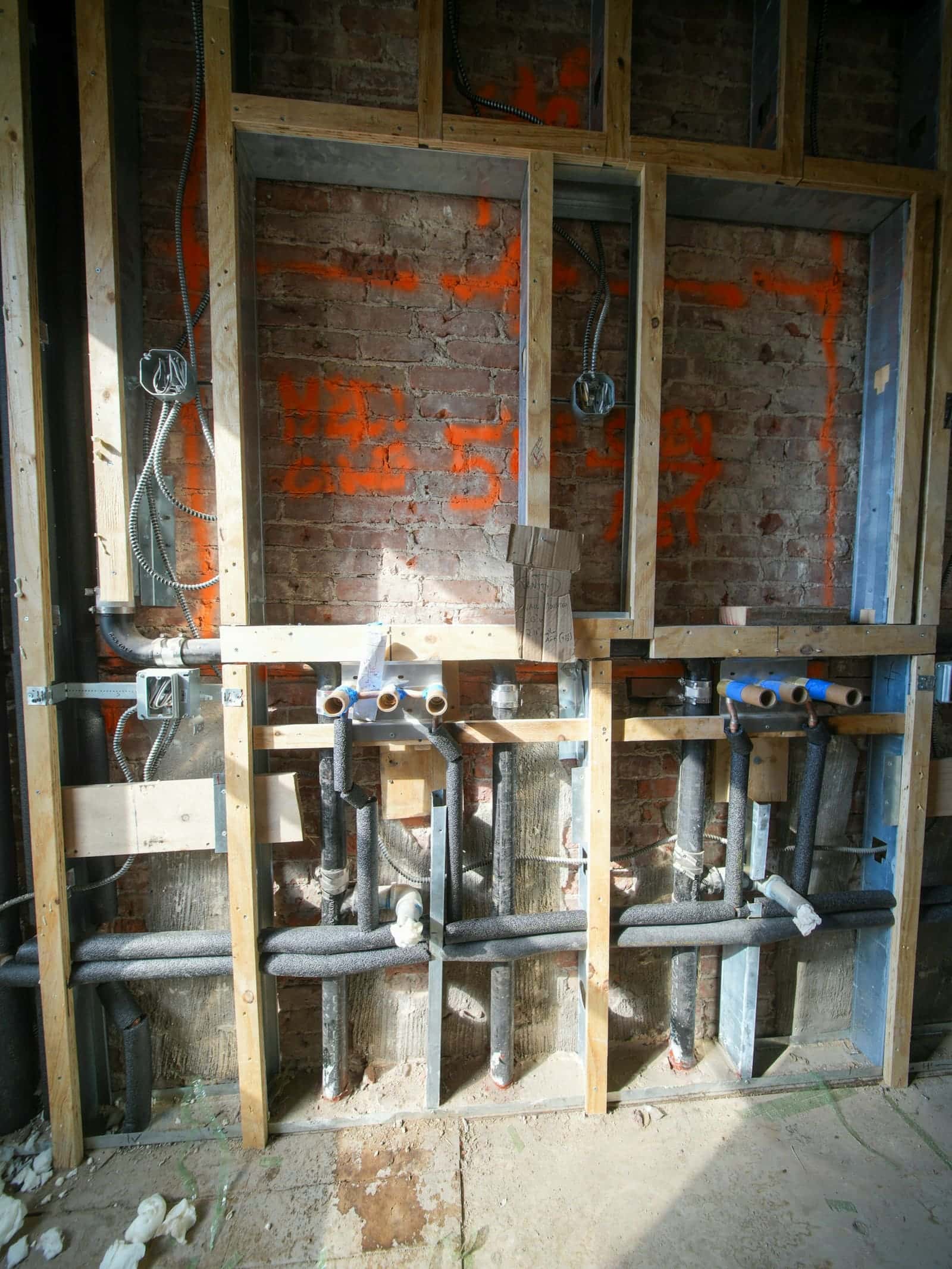 Water supply lines and fittings inside an open wall during renovation