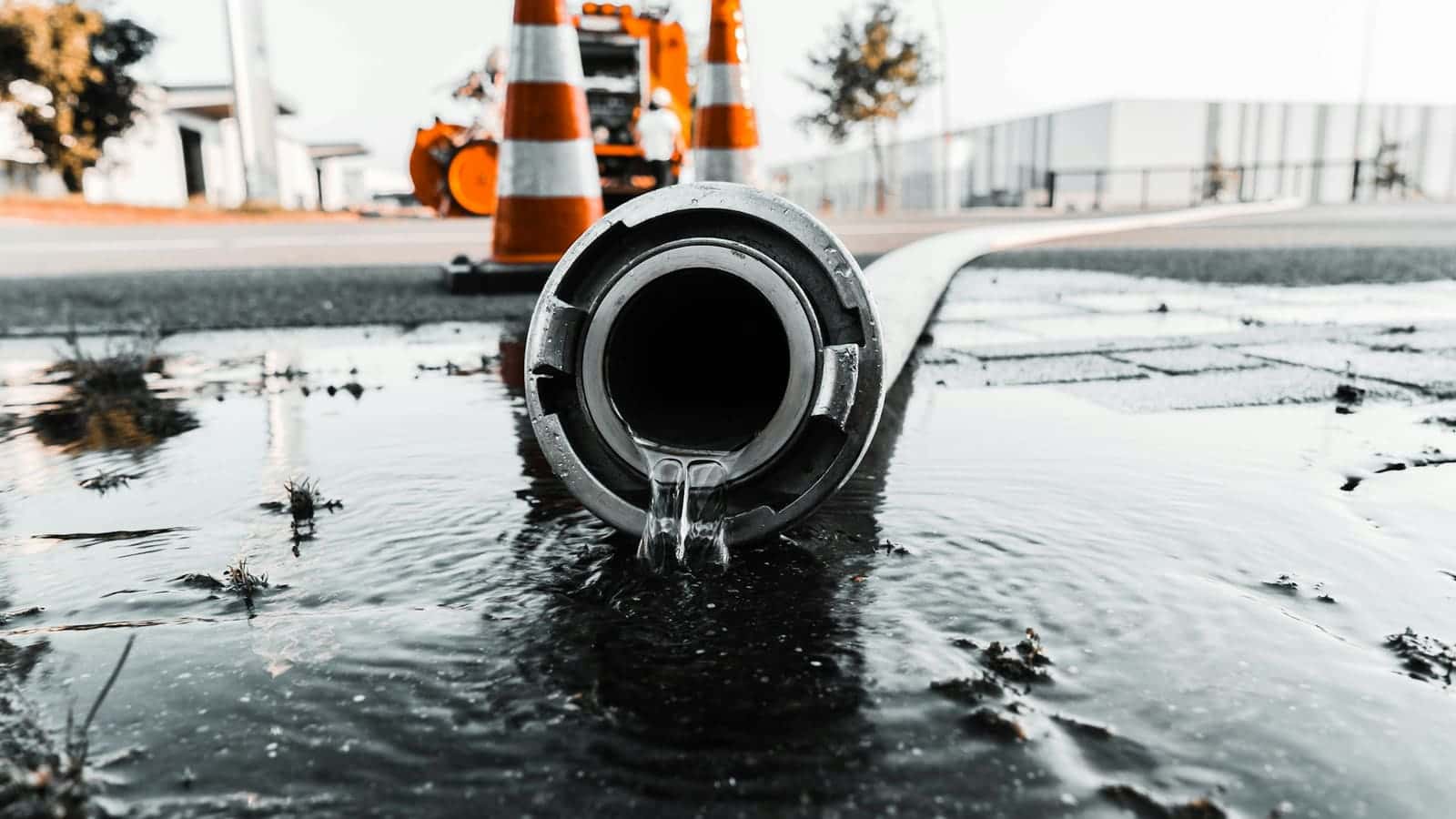 Water pouring from a large pipe at a street work site