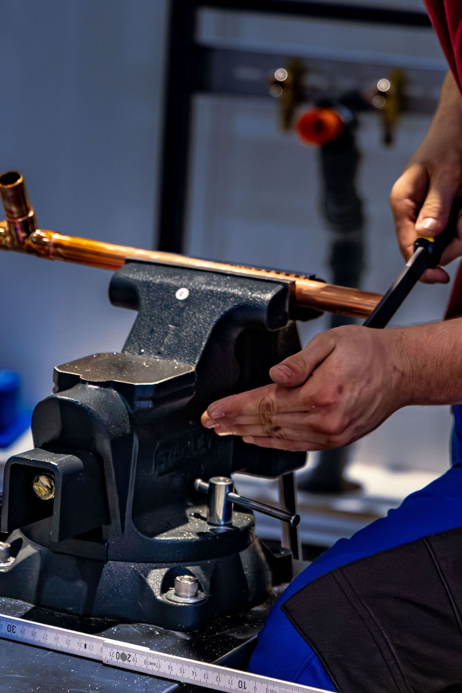 Plumber bending copper pipe with a pipe bender