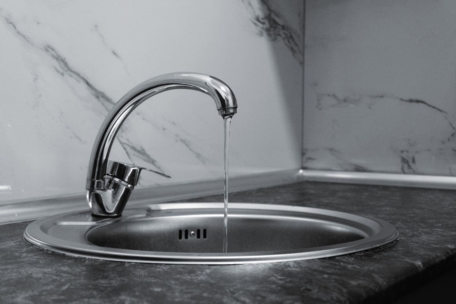 Chrome kitchen faucet running into a sink