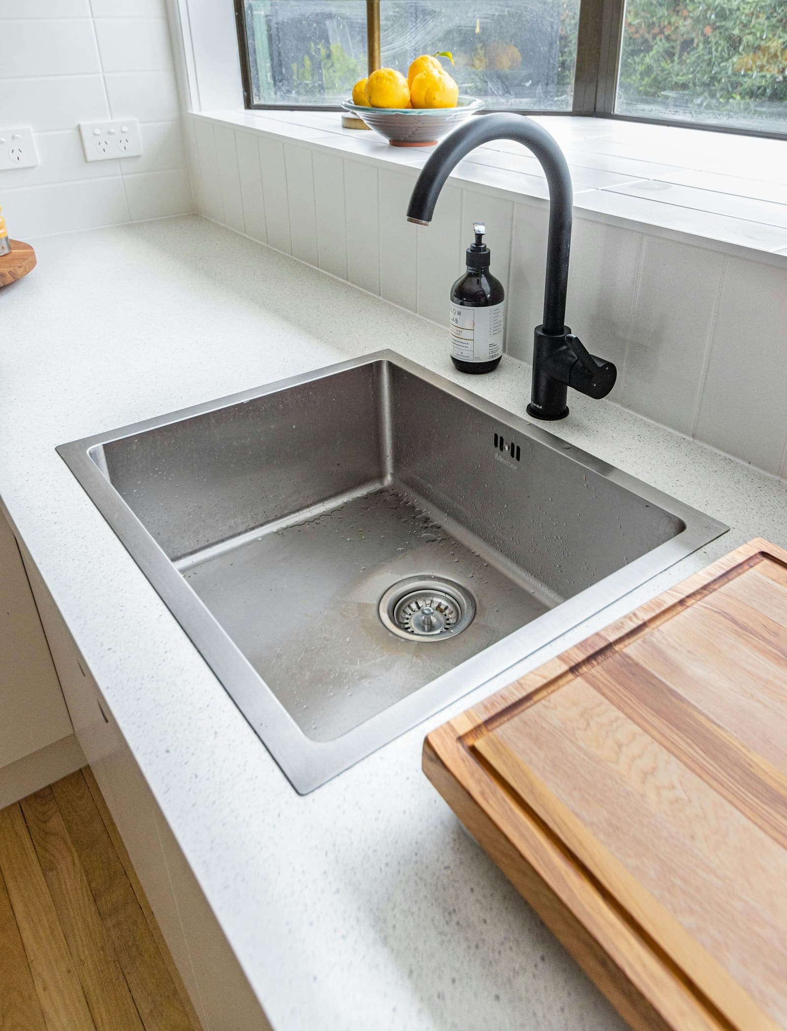 Stainless steel kitchen sink with a black faucet